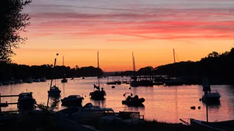 BBC Weather Watcher Soo Silhouetted boats in a harbour area under a low sun 