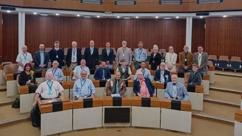 Reform A group of councillors from Reform wearing smart clothes in County Hall