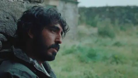 MAB Rabbit Ltd 2024 A man sat against a wall staring ahead 