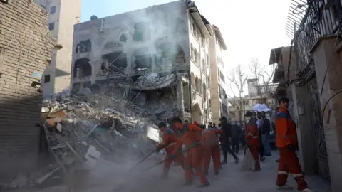 Iranian workers clear rubble at the site of a synagogue that was destroyed in an Israeli air strike, in Tehran, Iran (7 April 2026)