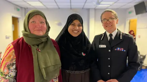 Kay Willoughby and Mahfuza Siddiqui, wearing headscarves and Chief Constable Rachel Kearton in police uniform