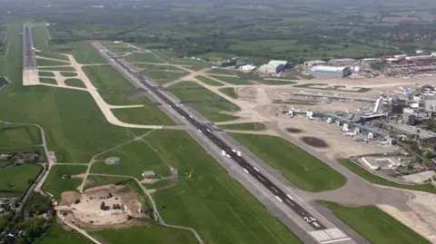 Aerial view of Manchester Airport showing two runways and the terminals