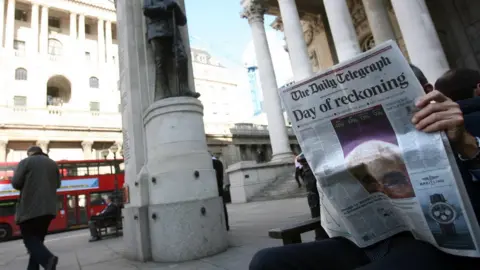 Getty Images Man reads newspaper outside the Bank of England