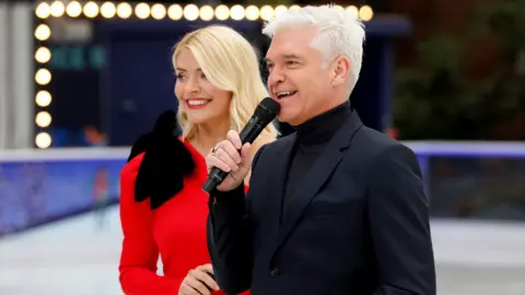 PA Media Holly Willoughby (left) and Phillip Schofield during the press launch for the upcoming series of Dancing On Ice at the Natural History Museum Ice Rink in London