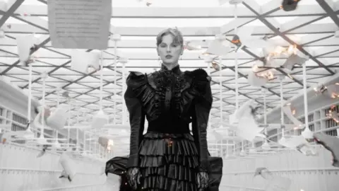 PA The black ruffled dress, as seen in the music video Fortnight, is one of number of objects on loan from Swift's personal archive