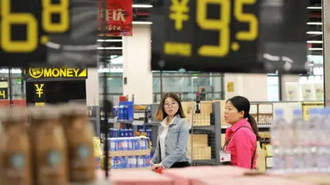Getty Images Customers at a store in Qingdao in China's eastern Shandong province on May 24, 2018.