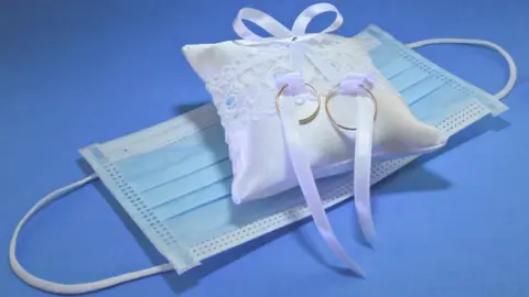 Getty Images A face mask and wedding rings - stock image