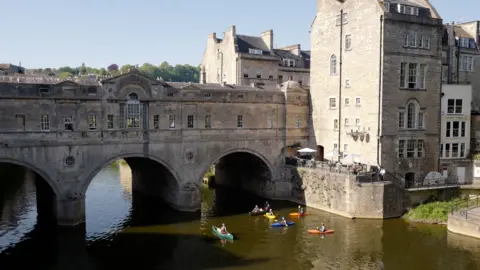 Getty Images A small group of canoeists is seen in the shadow of Pulteney Bridge in the centre of Bath on a hot day.