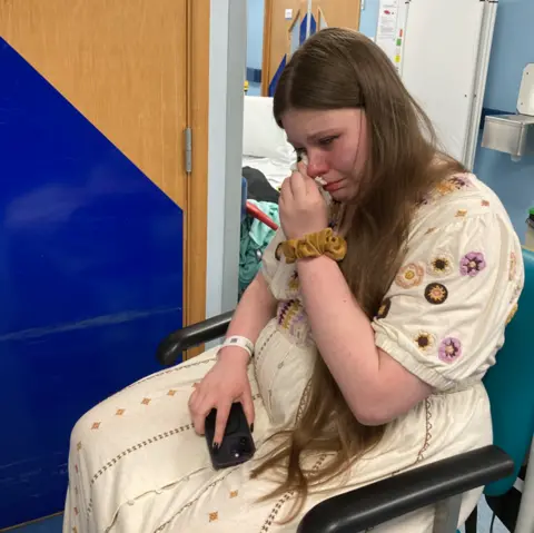 Johanna Dart Johanna sitting in a hospital padded chair crying