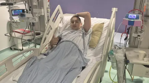 Lloyd Griffiths Ethan in a hospital bed 