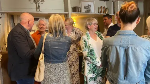Family members standing and chatting at the bar in The Chapter House, Salisbury