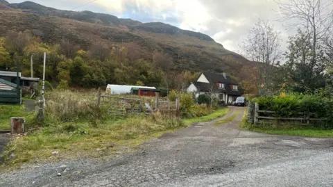 A location   astatine  the extremity  of a track. There is simply a van parked extracurricular  it. Behind the location   is simply a hill.