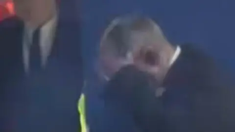 Instagram A steward holds his hand to his head after being struck by a flare