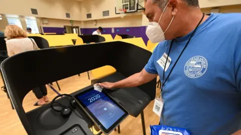 Getty Images Poll worker cleans voting machine