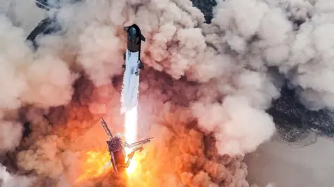 Reuters SpaceX's Starship taking off from its flight pad, strong orange flame emitted from the base of the rocket and clouds of billowing smoke surround it