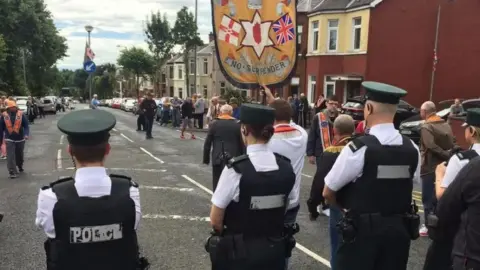 BBC Members of the three lodges involved in the Ardoyne parade dispute arrived at police lines led by the Ballysillan banner in 2016