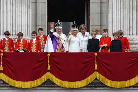 Matthew Childs / Reuters King Charles and Queen Camilla stand on the Buckingham Palace balcony following their coronation ceremony