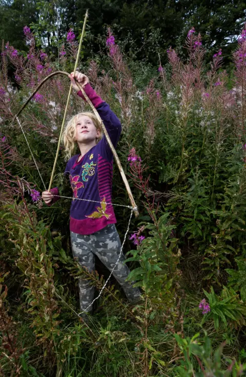 Richard Jinman Portrait of Jessica holding a bow and arrow in a meadow