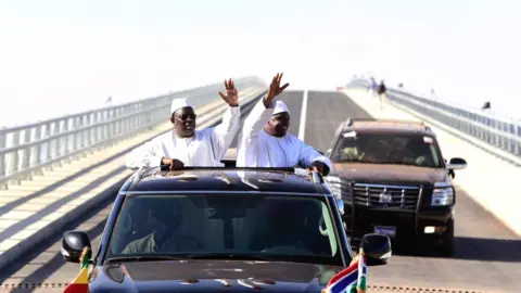 AFP Senegal's President Macky Sall (L) and Gambia's President Adama Barrow (R) wave as they inaugurate a bridge in Farafenni