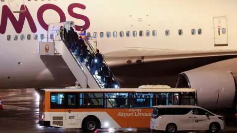 Reuters People boarding evacuation flight at Haneda Airport