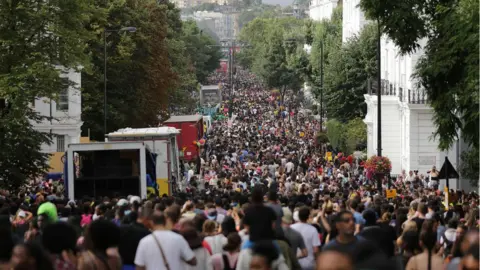 DANIEL LEAL-OLIVAS Revellers line the streets on the first day of the Notting Hill Carnival