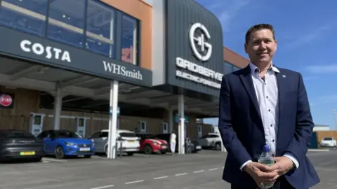 Toddington Harper standing outside the Gridserve electric forecourt in Norwich