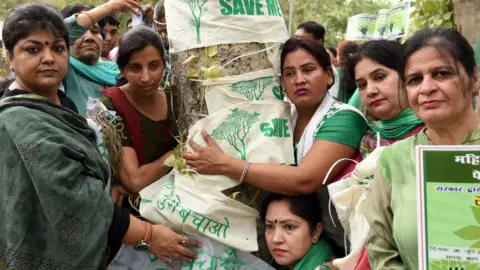 Getty Images Delhi residents hug a tree
