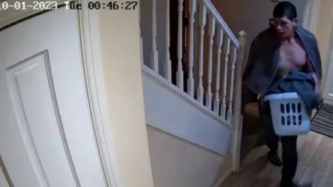 Cambridgeshire Police Jamie Boughen on CCTV carrying a laundry basket with clothes in it