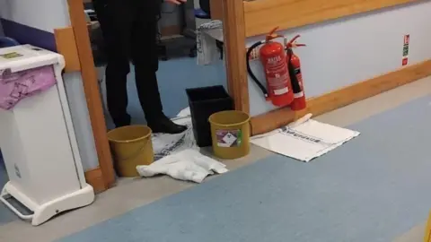 Buckets and towels on the floor being used to catch dirty water that is leaking into the cancer unit at the Royal Sussex County Hospital in Brighton