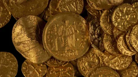 A close-up of the West Norfolk hoard which includes detail of a Byzantine gold solidus. The hoard is a group of gold coins.