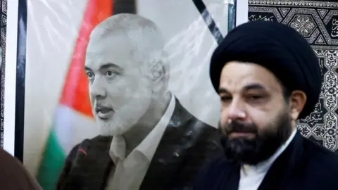 Reuters A man mourns next to a poster of Ismail Haniyeh in Tehran (01/08/24)