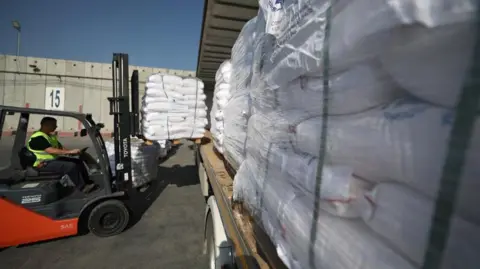 EPA A forklift driver loading pallets of aid onto the back of a lorry