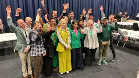 Euan Doak/BBC The Green Party members cheer in Manchester following led by Gorton and Denton MP Hannah Spencer