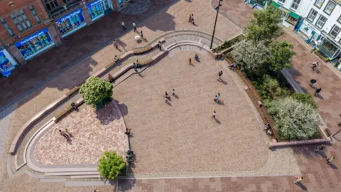 Cumberland Council Artist impression of what Greenmarket will look like following the regeneration project. A plaza has a red brick floor and trees are dotted around the open space.