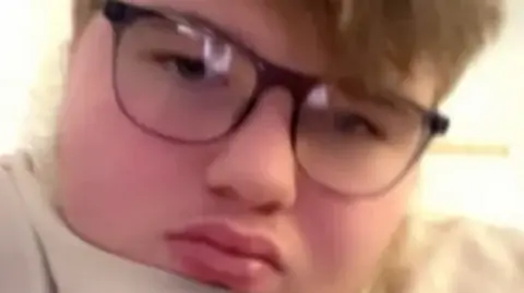 Supplied A teenage boy with glasses looking at the camera. He has short brown hair and is wearing a white jumper.  