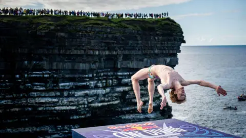 Romina Amato/Red Bull via Getty Images Gary Hunt of France backflips in reaction to the crowd, prior diving from the 27.5 metre platform during the final competition day of the fourth stop of the Red Bull Cliff Diving World Series on September 12, 2021 at Downpatrick Head, Ireland