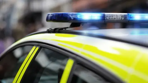 Police siren flashing blue lights at accident or crime scene.