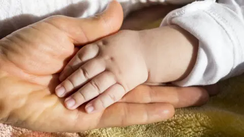 Thinkstock Baby's hand holding adult's hand