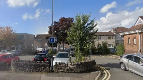 Google Image of an urban car park in the Staple Hill area of Bristol showing several parked cars, surrounded by residential housing