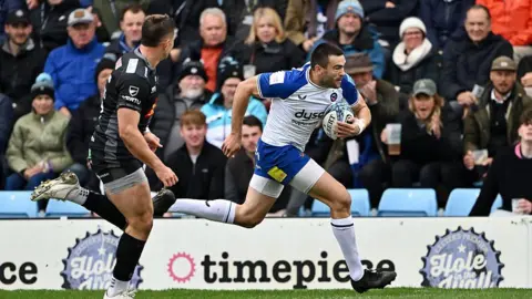 Will Muir, with ball in hand, prepares to dive to score a try as an Exeter defender looks on 