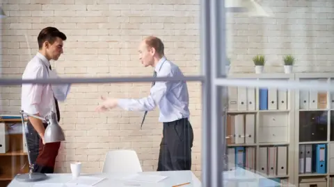 Getty Images Two people argue in an office