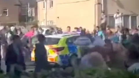 Crowds attack a police vehicle in Grimsby
