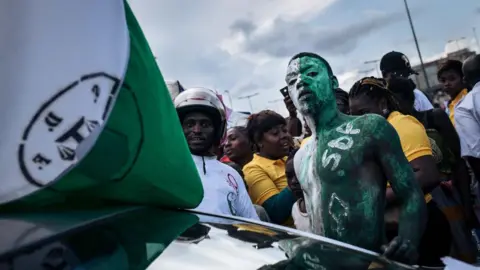 AFP through Getty Images of a man painting with green and white 