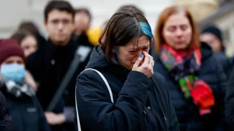 A woman cries during a vigil to the victims of those killed in Prague, Czech Republic