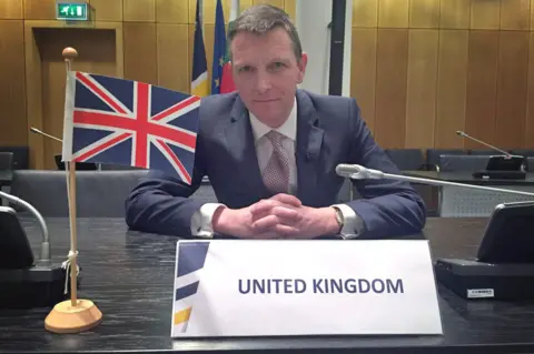 BBC Mark Easton with UK flag in Europol boardroom