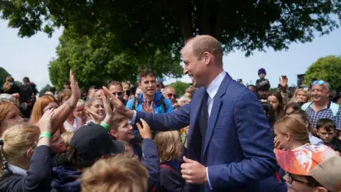 PA Media Prince William high fives a group of children from Hingham Primary School