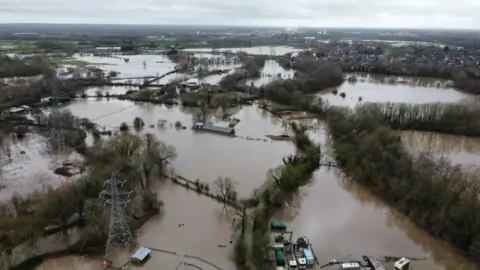 Davinia Ramos/BBC An aerial image of fields submerged in brown floodwater