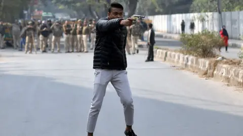 Reuters An unidentified man brandishes a gun during a protest against a new citizenship law outside the Jamia Millia Islamia university in New Delhi, India, January 30, 2020