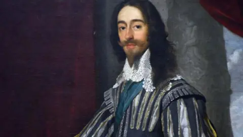 Getty Images A portrait of a man dressed in elaborate 17th‑century clothing with a styled beard and shoulder length hair. 