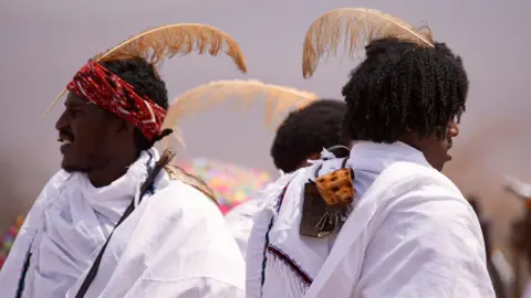 Amensisa Ifa / BBC Young men wear feathers in their hair to show their status as initiates.